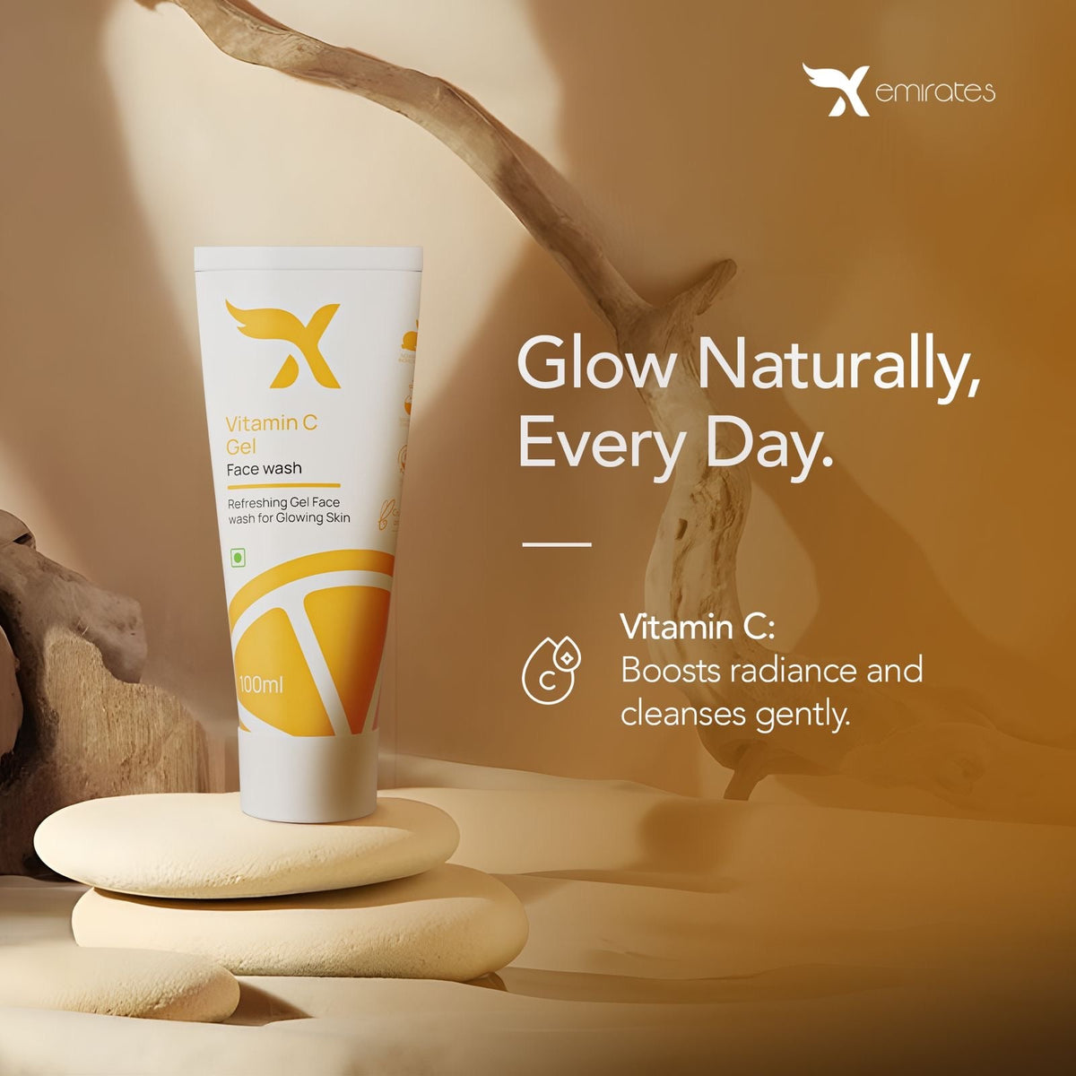 A tube of Vitamin C gel face wash displayed against a neutral background with a branch prop. The packaging is white with a yellow label, and the product is positioned in front of a light source, creating a shadow on the surface. XCosmetics | Cream X Emirates